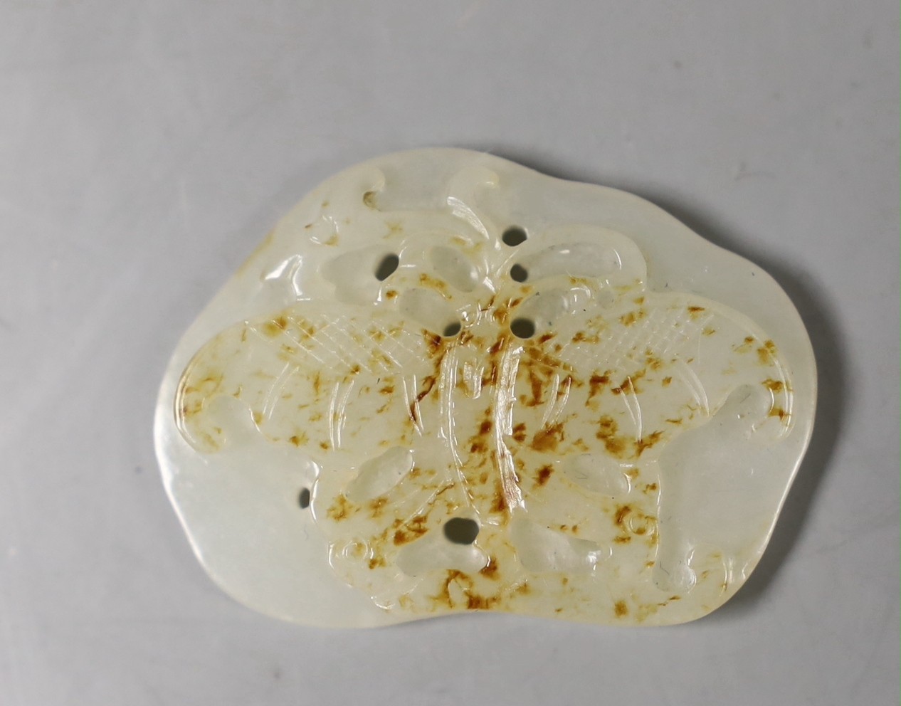 A Chinese white and russet sling jade ‘butterfly’ plaque, 3,5 cms long